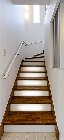 階段下の納戸に照明を備え付けたので、夜はフットライト（足元灯）として照らします。