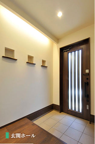 優しい光でお客さまを迎える間接照明とニッチのある玄関。