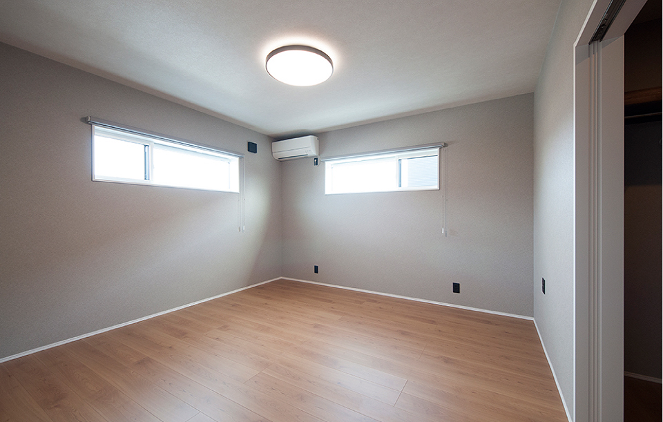 グレーの壁でトーンを抑え、落ち着いた雰囲気に仕上げた洋室。